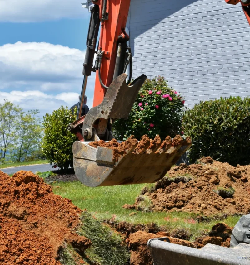 excavator-digging-soil-near-suburban-home-on-sunny-2026-03-19-23-48-57-utc (1)